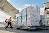 Employees on the ramp at Worldport move a pallet of iPhone and iPad shipments