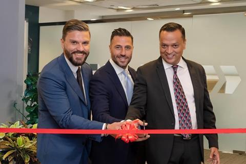 Genaro, Ayman, and Leslie cutting ribbon for Abu Dhabi office opening