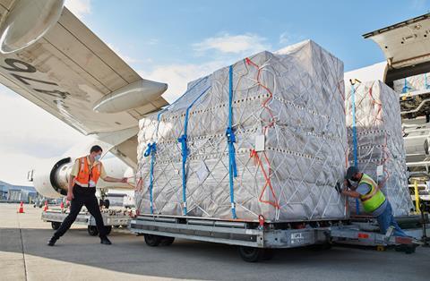 Employees on the ramp at Worldport move a pallet of iPhone and iPad shipments