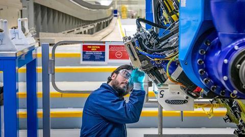 A mechanic prepares to operate the automated fibre placement machine that is building the spars for the wings of the first 777-8F